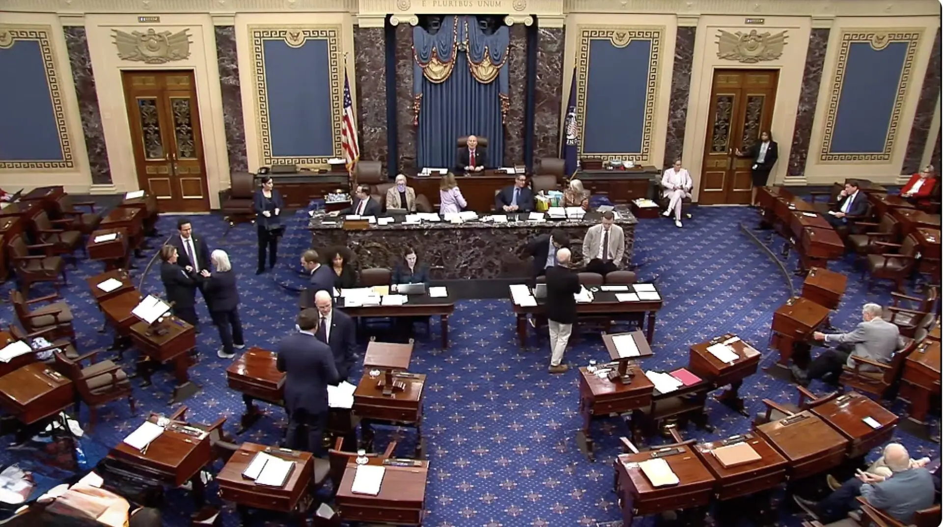 Government officials in a formal meeting room.